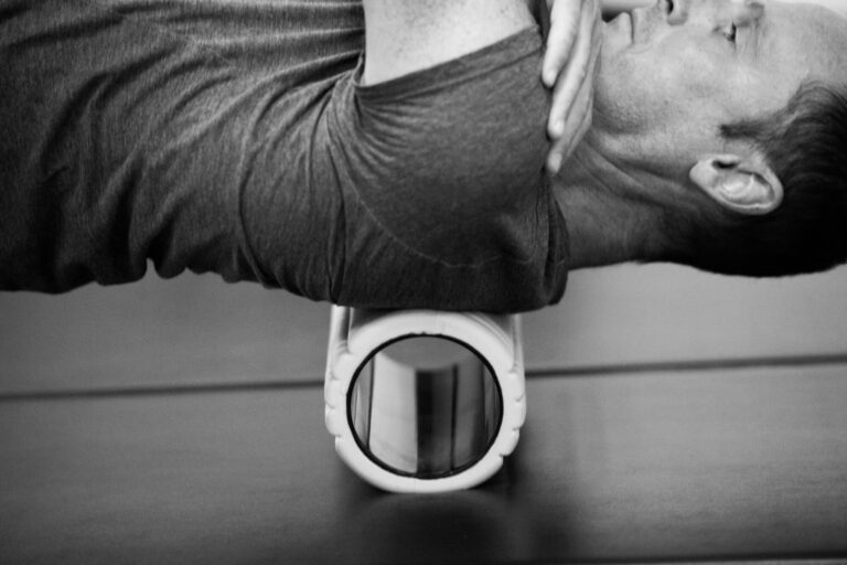Persona che esegue esercizi di rilascio miofasciale con foam roller per migliorare la postura e ridurre la tensione dorsale a Parma
