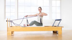 esercizio di twist al Reformer per migliorare la mobilità della colonna e potenziare gli obliqui dell'addome